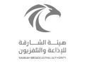 Grey logo of the Sharjah Broadcasting Authority with Arabic and English text.
